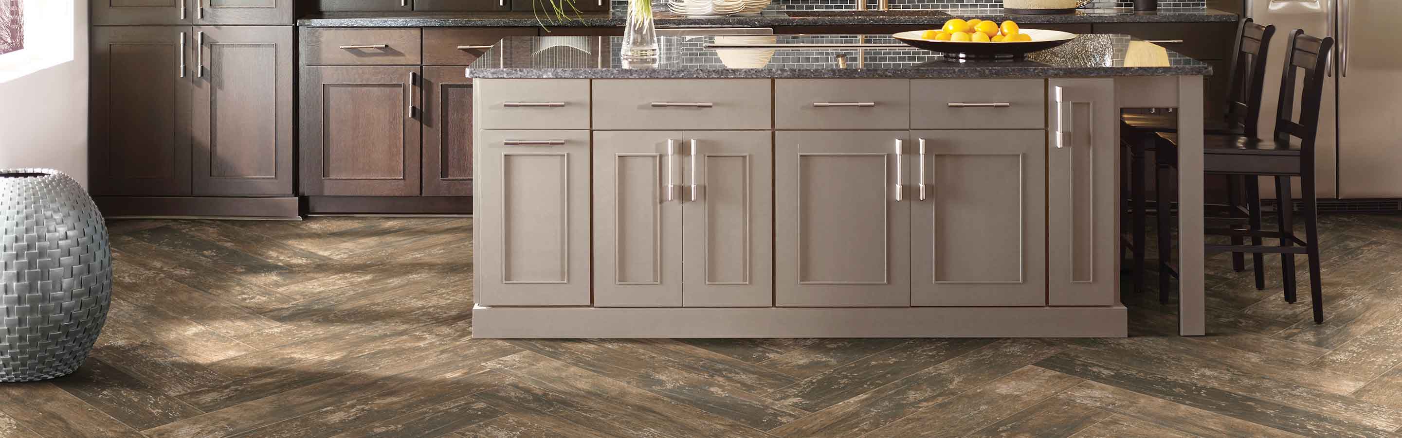 Herringbone tile floor in kitchen with island and hanging lights. 