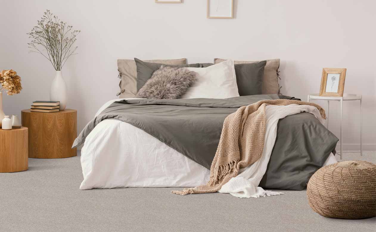 contemporary bedroom with soft grey carpet and neutral furniture and wood accents
